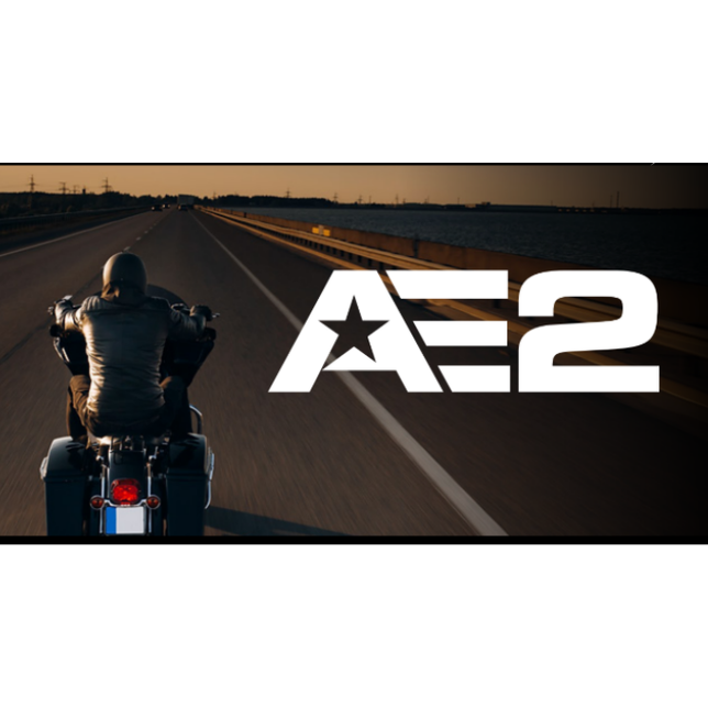 Motorcyclist riding Dunlop AE2 bias rear tire on open highway during golden hour