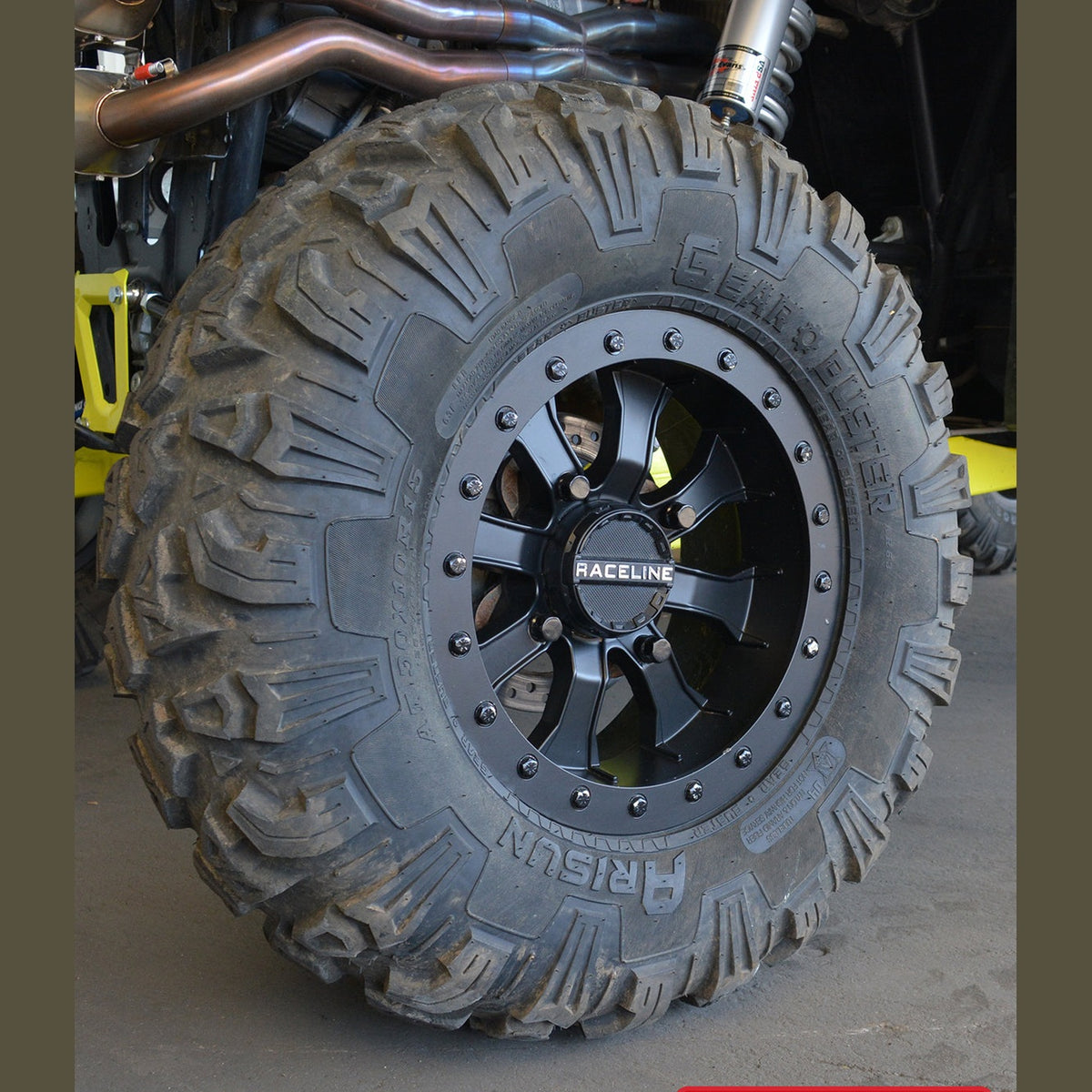 Close-up of matte black Raceline wheel mounted on muddy off-road tire